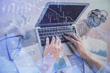 Multi exposure of forex graph with man working on computer on background. Concept of market...