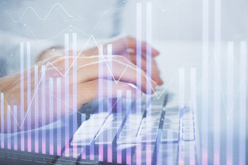 Multi exposure of graph with man typing on computer in office on background. Concept of hard work. Closeup.
