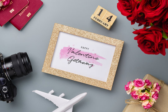 Mockup golden picture frame for travel with valentines day & love season background concept. Top view of mock up photo frame with rose flowers, craft roses, passport, camera, airplane model 