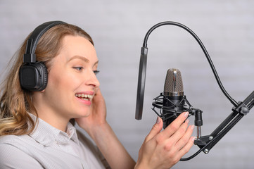 Emotional reading a girl news on the radio, in the studio with a studio microphone. Podcasts,...