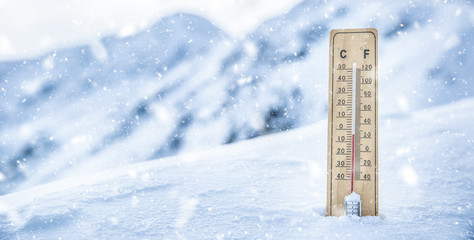 Thermometer on the mountains in the snow shows temperatures below zero. Low temperatures in degrees Celsius and fahrenheit in snowy weather