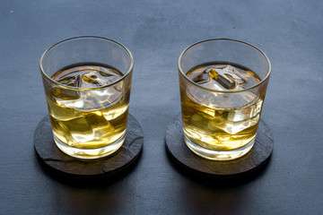Scotch - two glasses with ice - on black background