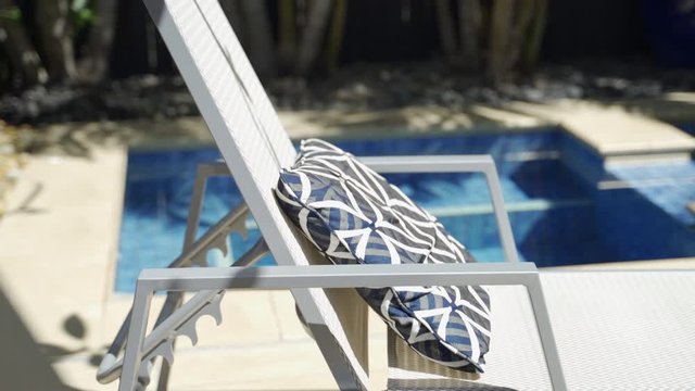 Close up of outdoor chairs and blue cushion on sunny day