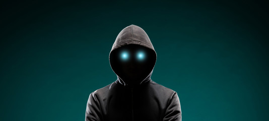 Computer hacker in hoodie. Obscured dark face. Data thief, internet fraud, darknet and cyber...