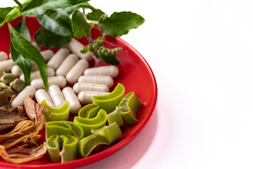 Macro shot of assorted Spices with ayurvedic capsule, green tulsi leaves and cut aloevera in a red...