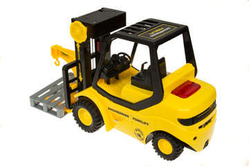 Children's  yellow toy forklift isolated on white background.
