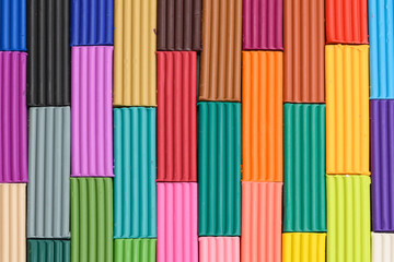 Colorful plasticine sticks in a cardboard box. Colorful plastic set of polymer clay on a white...
