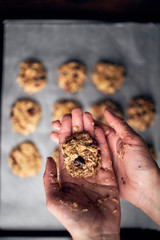 Hands showing breakfast cookie dough prepared for baking in oven	