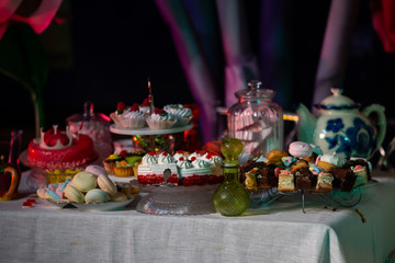 Dessert table for a party. Ombre cake, cupcakes, sweetness and flowers