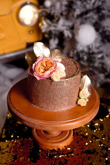 Chocolate cake with raspberry filling and pistachio cream, decorated with roses and golden jelly sparkles in the New Year's interior