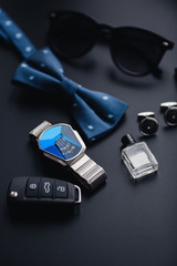 Luxury fashion men's cufflinks. Accessories for tuxedo, butterfly, tie, handkerchief, style watch and smartphone, car key isolated on the black background.
