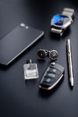Luxury fashion men's cufflinks. Accessories for tuxedo, butterfly, tie, handkerchief, style watch and smartphone, car key isolated on the black background.
