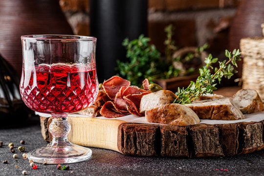 Georgian cuisine. Pomegranate ?hacha alcoholic drink with assorted different cured sausages and meat. Serving dishes in a Georgian restaurant. background image, copy space