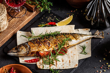 Georgian cuisine. Grilled mackerel fish with vegetables and rosemary. Serving dishes in a Georgian...