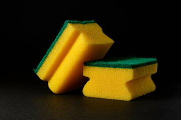 two new yellow sponges against black background