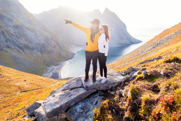 Fototapeta premium Happy couple of love are hiking on top of Mountain in Lofoten island, Norway