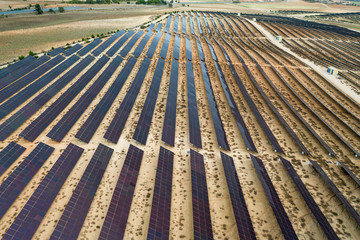 Drone aerial shooting of solar power farm raws of reflective panels. At cloudy day.