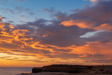 Early sunrise and epic cloudy sky at rocky seashore coast of Torrevieja, Alicante, Spain. Mediterranean sea 2019