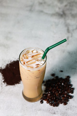 Iced latte fresh coffee put on the stone table with bean and powder coffee. Fresh drink with good raw material for good taste.