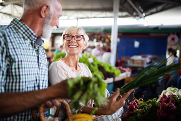 Only the best fruits and vegetables. Beautiful mature couple buying fresh food on market