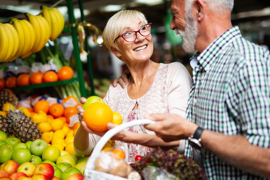 Portrait of beautiful elderly couple in market buing food