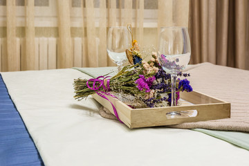 still life decoration from two empty wine glasses, a home-made rag angel toy and  bouquet of dried flowers.