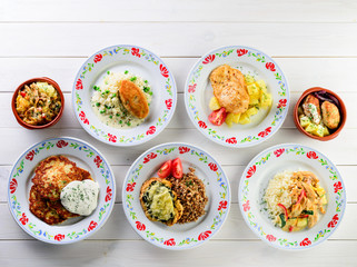set of homemade food in plates on a white wooden table