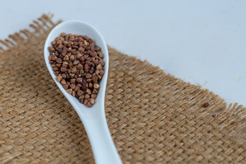 Buckwheat raw, medium rare. Measured for making porridge. On a gray background under concrete.