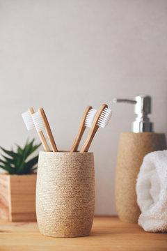 Four bamboo toothbrushes in a cup in the bathroom
