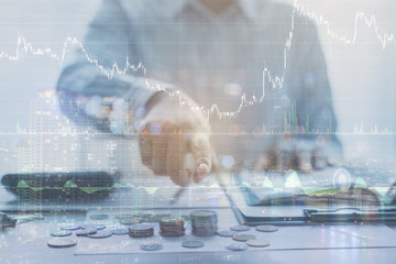 Double exposure of graph and rows of coins currency exchange rates in the world market for finance...