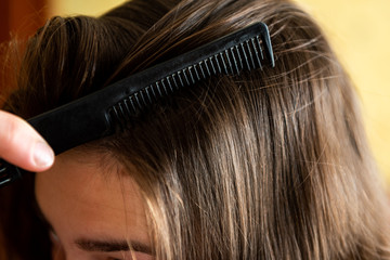  Close up woman combing hair.