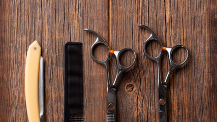 Barber scissors and razor. Hairdresser tool. Barber tool on a wooden background top view.