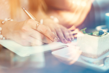 Woman making notes while sitting in a coffee shop