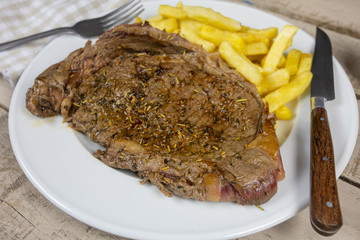 entrecôte de boeuf grillée et frites dans une assiette