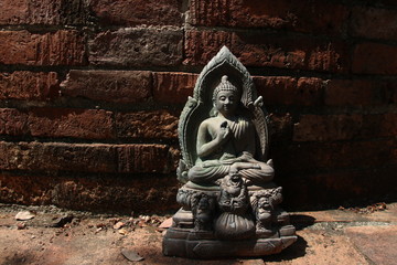 A Buddha statue and retro bricks wall, sun light on Buddha statue, Thailand.