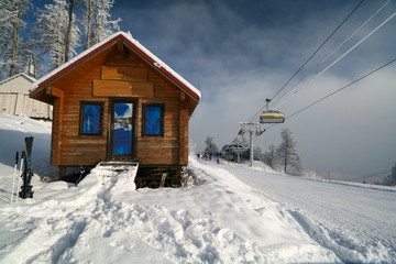 Wooden house and cable car in the Rosa Khutor ski resort, Sochi, Russia.