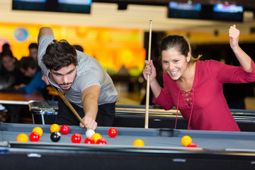 young couple playing pool woman winning