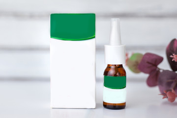 spray for a nose with a box of light white lie on a white table