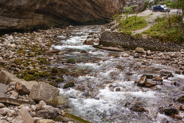 Beautiful mountain rivers of bright blue color in the mountains of Abkhazia on the road to Lake Ritsa on a summer sunny day. Mountain valley.