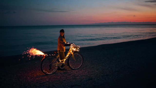San Valentino, la festa degli innamorati. Ragazza da sola in bici la notte vicino al mare