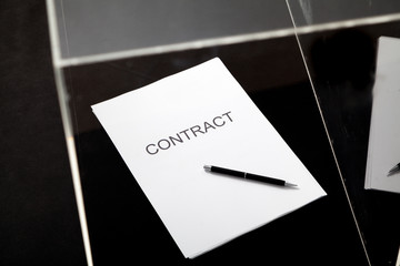 Contract and pen lie in transparent box