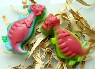 Handmade soap in the shape of dinosaurs on a white background. 