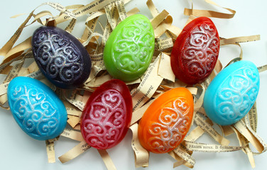 Handmade soap in the shape of multicolored eggs on a white background. 