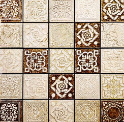 Beige vintage ceramic tiles with ornaments for wall and floor decoration. Concrete stone surface background. Texture with patterns for interior design project.