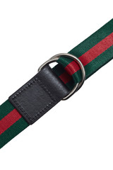 Cropped detail shot of a striped green and red canvas belt with black leather trim and decorated with a steel D-rings buckle. The stylish belt is isolated on the white background.