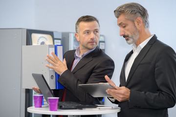 Fototapeta premium businessmen looking at tablet screen while on coffee break
