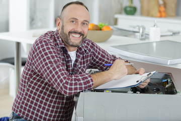 happy man fixing a washing machine