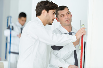 builders is measuring wall with level