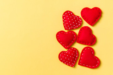 Composition of textile red hearts on colorful background with empty space for your design. Top view of St. Valentine's day concept