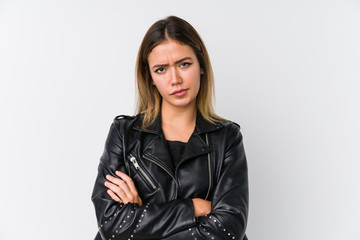 Young caucasian woman wearing a black leather jacket frowning face in displeasure, keeps arms...